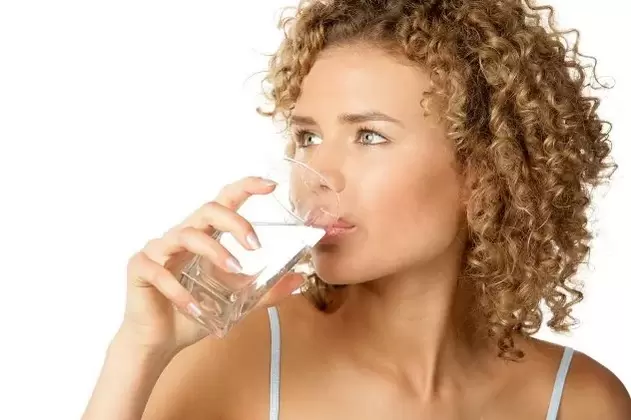 Το κορίτσι κάνει μια τεμπέλης δίαιτα και πίνει ένα ποτήρι νερό πριν φάει